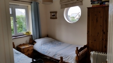 Back twin bedroom with porthole window